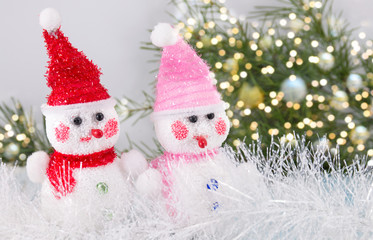 Two toy snowman with festive background