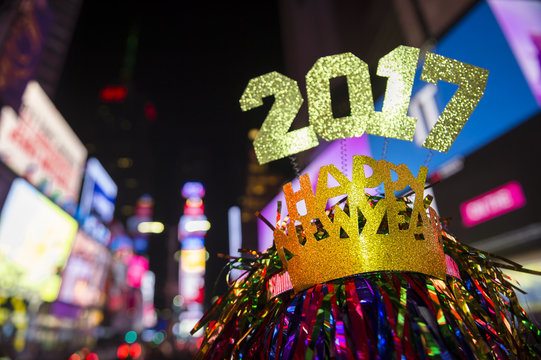 Glittery 2017 Happy New Year message with celebration tinsel flying on novelty party hat in Times Square, New York City