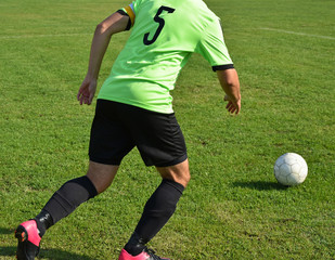 Soccer player runs with a ball