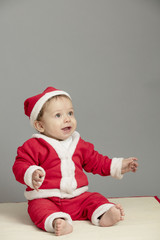 Caucasian baby in Santa Clothes isolated inside studio