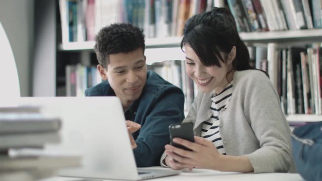Students using smartphone in library
