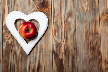 Ripe red apples on a wooden background. Top view. Vegan concept.