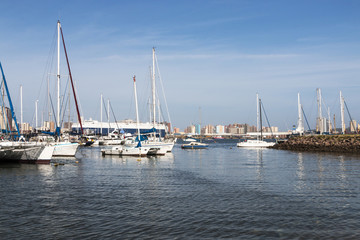 Fototapeta premium Vessels Moored at Yacht Mole Against City Skyline