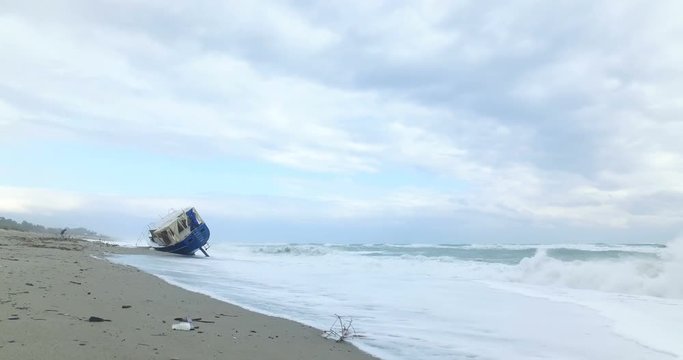 Barca degli immigrati arenata sulla costa dopo una forte tempesta in mare. 