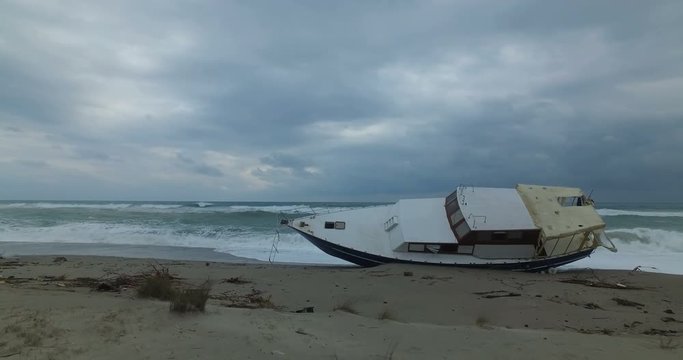 Barca degli immigrati arenata sulla costa dopo una forte tempesta in mare. 