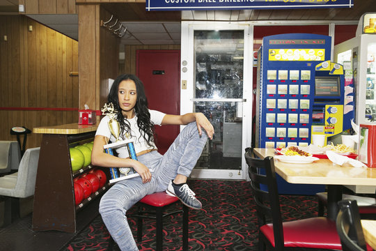 Beautiful young woman eating at a bowling alley