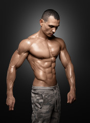 Fototapeta na wymiar Strong Athletic Man Fitness Model Torso showing big muscles