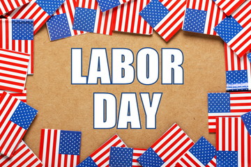 Flags of the United States of America arranged in a border around the words Labor Day, a public holiday to celebrate the contribution of workers