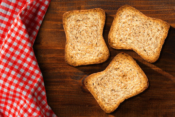Rusks of wholemeal flour on a wooden table with checkered tablecloth