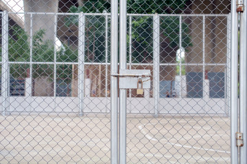 Padlock / View of padlock on steel mesh door.
