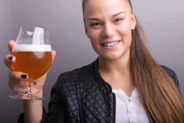 Young woman holding fresh beer. isolated gray.