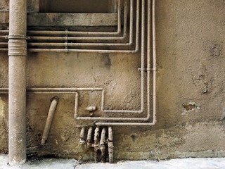 Urban ghetto pipe plumbing against grungy wall texture