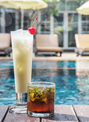 two cocktail mojitos and pina colada in the misted glasses on th