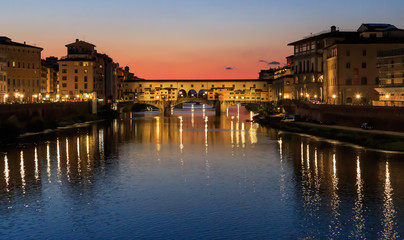 Fototapeta na wymiar Ponte Vecchio - the oldest bridge of the city of Florence. River Arno, sunset, Tuscany, Italy, the reflection in the water.