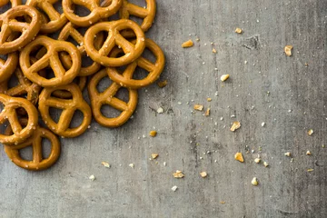 Gartenposter Salted pretzels on wooden background © chandlervid85