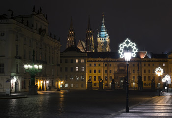 Prague, Czech Republic / Czechia - Hradcany square during night. Prague castle and Saint Vitus Cathedral in the background. Lamp with christmas decoration during winter season