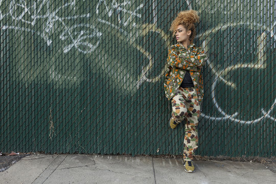 Young woman standing against wall