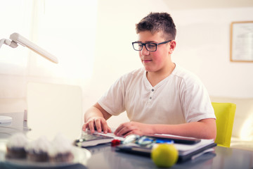 Teenage boy relaxing at home using laptop