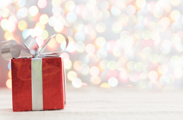 Decorative red gift box with a large silver bow and background b