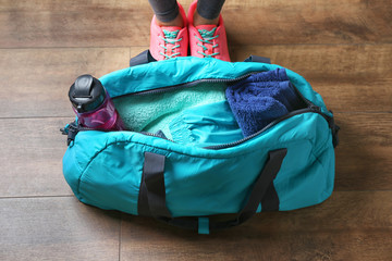Woman standing next to bag with fitness equipment