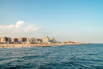 Fototapeta premium Roller coaster and buildings cityscape on the Brighton Beach. It is known for its high population of Russian-speaking immigrants, and as a summer destination for New York City residents.