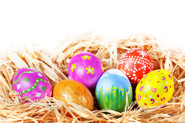 Fototapeta na wymiar Hand painted Easter Eggs in a raffia nest