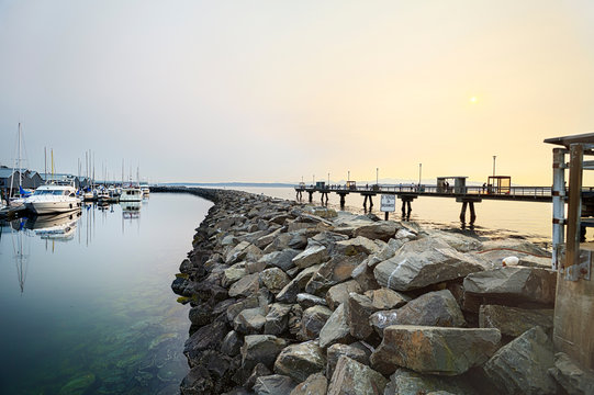 Hazy summer sun going down over the fishing pier in Edmonds