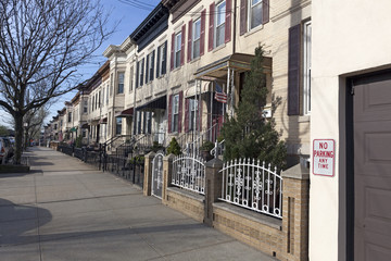 Neat and tidy city block of homes with short iron fences. Horizontal.