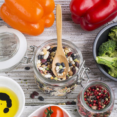 Assorted legumes grains on a light background with ripe tomatoes, olive oil, herbs, pepper ingredients for lunch or dinner. Top view. The concept of  healthy home-cooked meal.