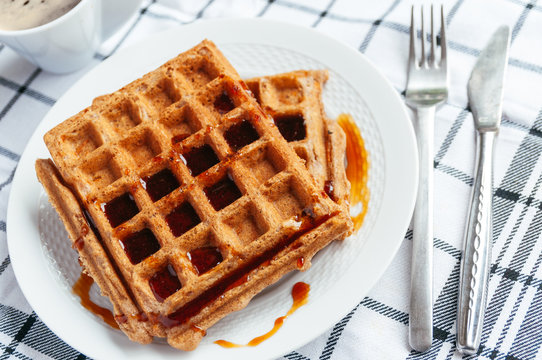 Spicy carrot waffles for breakfast with maple syrup and coffee