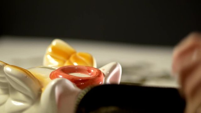 The female hand puts a coin from purse in the piggy bank