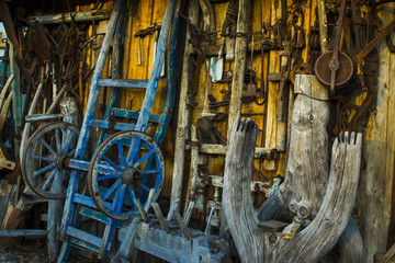old tools hanged on a wall, in evidence a blue wagon