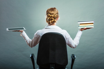 Woman holding traditional book and e-book reader