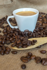Cup and grain of coffee over textile background