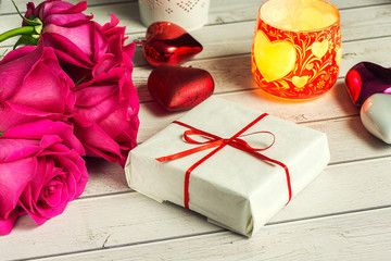 Romantic composition with rose flowers, candle and gift St. Valentines Day background