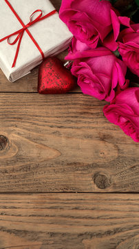 Romantic composition with rose flowers and gift St. Valentines Day background vertical. Copy space