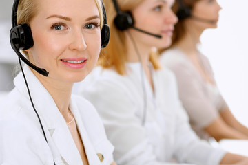 Call center. Focus on beautiful woman in headset