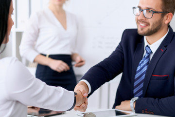 Business handshake at meeting or negotiation in the office. Partners are satisfied because signing contract or financial papers