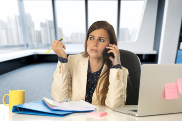 businesswoman suffering stress at office computer desk looking w