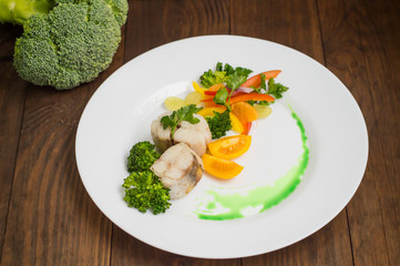 Boiled seabass with steamed vegetables - totally healthy meal. Top view. Close-up