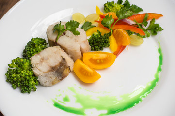 Boiled seabass with steamed vegetables - totally healthy meal. Close-up