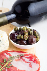 red wine, olives, capers and sun-dried meat closeup