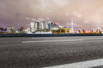 Fototapeta na wymiar Asphalt road and modern cityscape at night in Shanghai