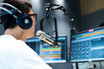 young man dj works in modern broadcast studio