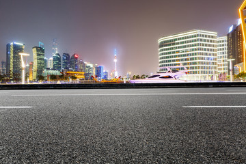 Obraz premium Asphalt road and modern cityscape at night in Shanghai