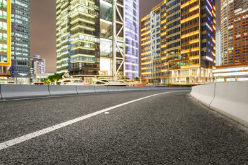 Asphalt road and modern cityscape at night in Shanghai