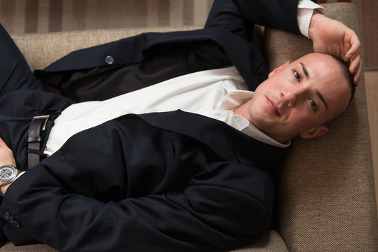 Young Businessman Sleeping on Sofa at Home