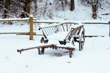 The old wooden cart in the snow