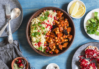 Vegetarian lunch table - eggplant and chickpea stew, bulgur, pomegranate and avocado. Top view, flat lay