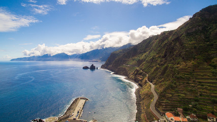 Obraz premium Coastal road with steep coast and beautiful blue ocean sky, Madeira, Portugal